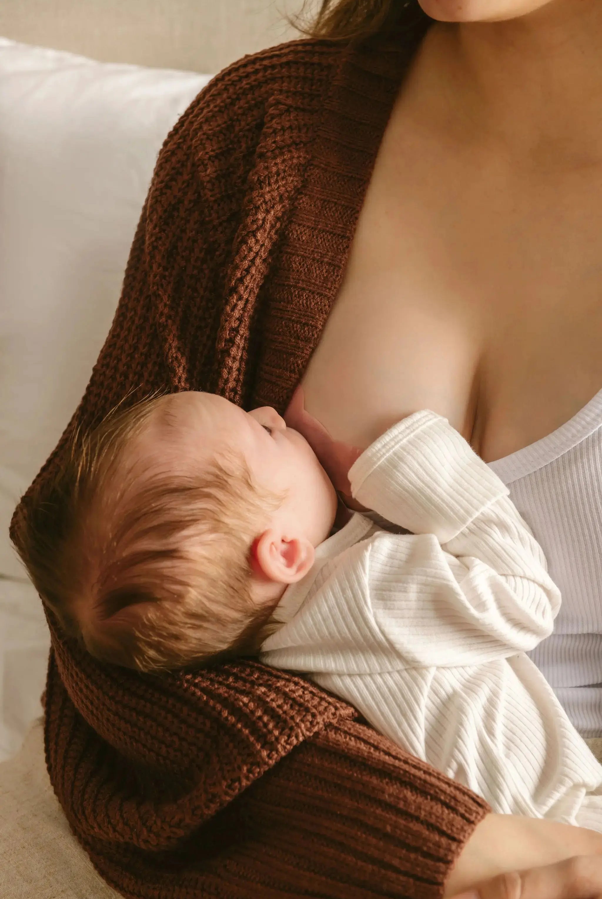 New Mom breastfeeding using soft tinted nipple shields designed to help newborn latching