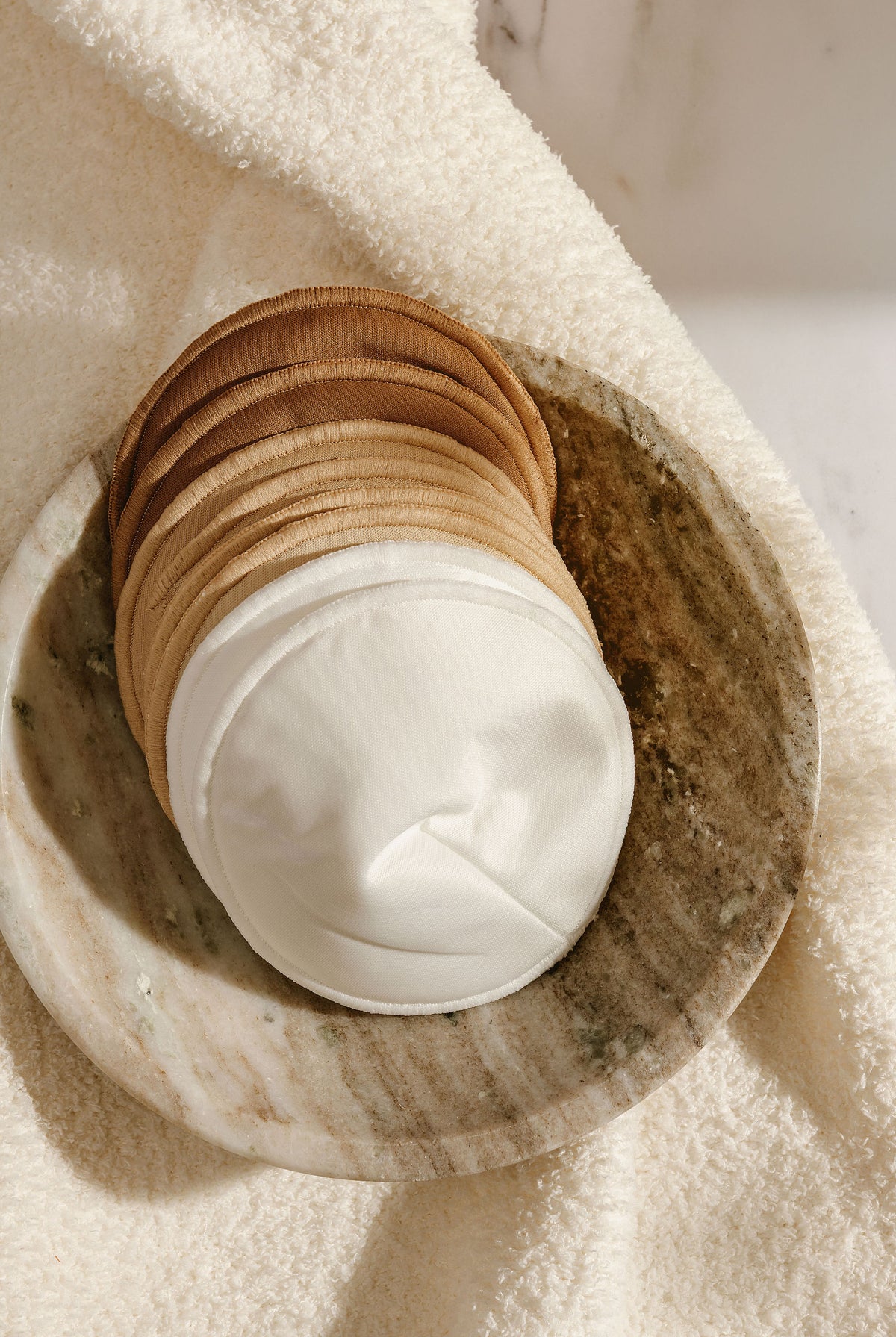 Reusable breast pad contoured to sit flat in a bra