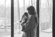 Parent paced bottle feeding a newborn held upright