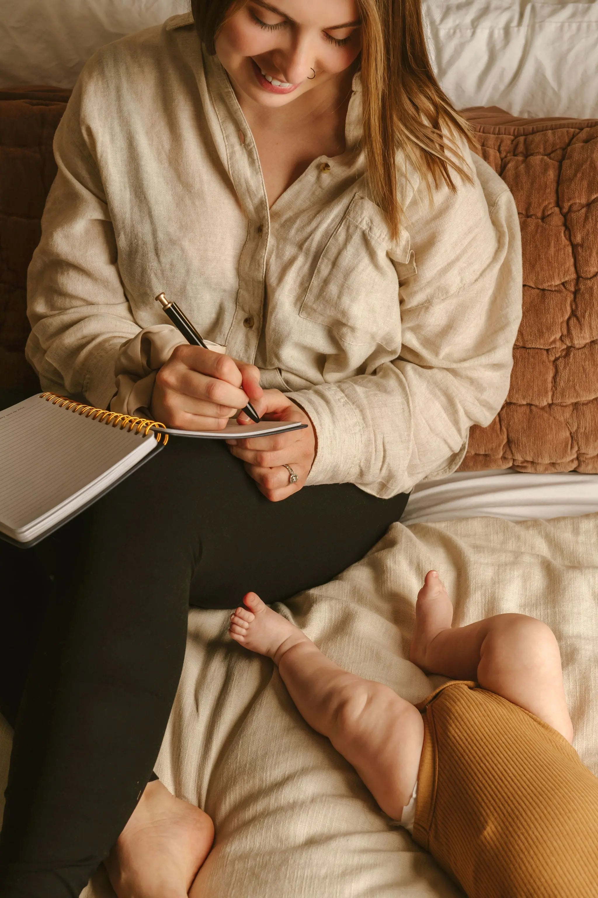 postpartum mom using Le Lolo postpartum journal and newborn tracker