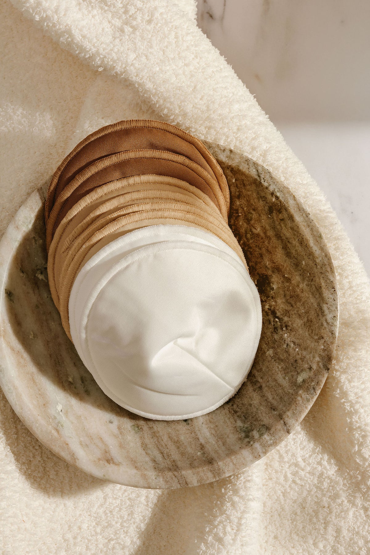 Reusable breast pad contoured to sit flat in a bra